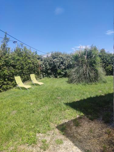 two chairs sitting in the grass in a field at Studio en pleine campagne in Le Thor