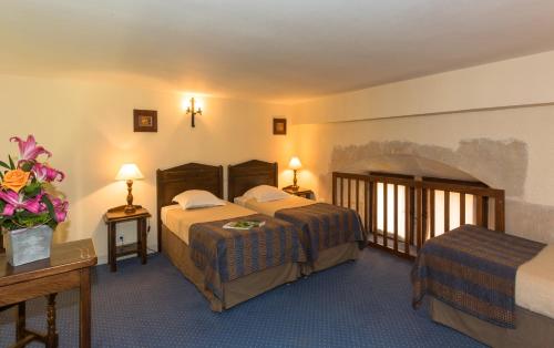 a hotel room with two beds and two tables at Chateau des Ducs de Joueuse, BW Signature Collection in Couiza