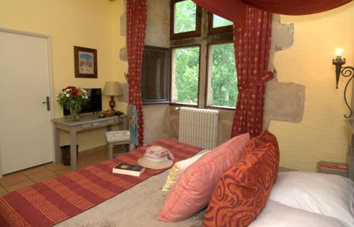 a bedroom with a canopy bed and a desk and window at Chateau des Ducs de Joueuse, BW Signature Collection in Couiza