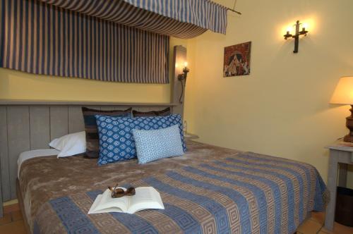 a bedroom with a bed with a book on it at Chateau des Ducs de Joueuse, BW Signature Collection in Couiza