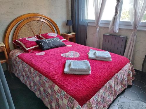 une chambre avec un grand lit avec une couverture rouge dans l'établissement Port City Arcachon Parking-Piscine, à Arcachon