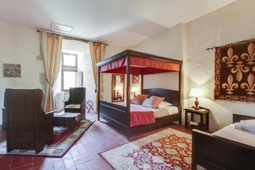 a bedroom with a canopy bed and a desk at Chateau des Ducs de Joueuse, BW Signature Collection in Couiza