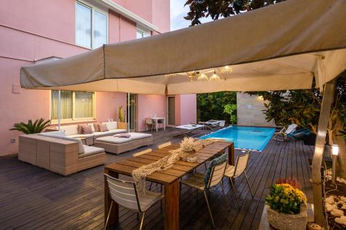 a patio with a table and a large umbrella at Villa Olimpia in Mondello