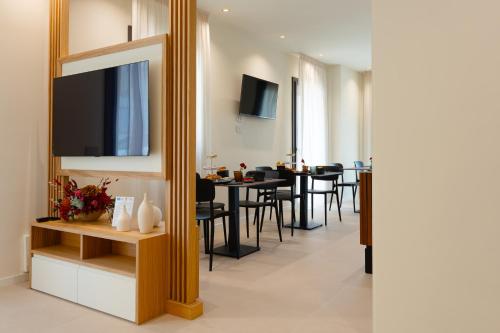 a living room with a mirror and a table with chairs at Hera Rooms and Suites in Agrigento