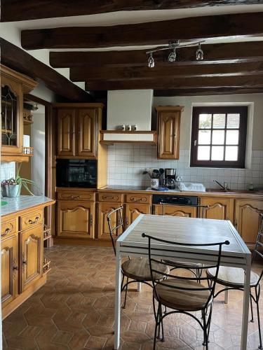 une cuisine avec une table et des chaises dans l'établissement Maison cozy la casa de Coronata Châteaux-Beauval, à Gièvres