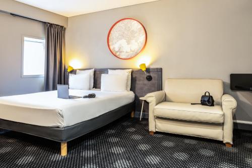 a hotel room with a bed and a chair at ibis Styles Paris Mairie de Montreuil in Montreuil