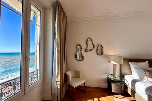 Un dormitorio con una cama y una ventana con el mar. en QUAI PROMENADE VIEW Balcony with breathtaking view, en Niza