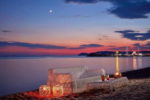 a white couch with lights on the beach at sunset at Icon Suites by the sea in Potos