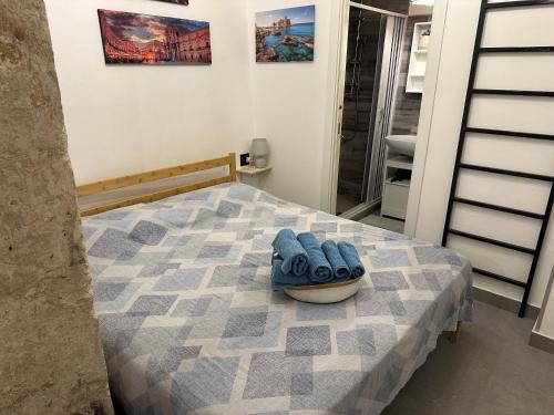 Un dormitorio con una cama con zapatos azules. en Nesea Home, en Siracusa