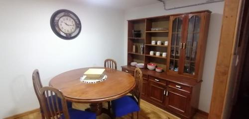 a dining room with a table and a clock on the wall at Rincón Puyehue Primer Nivel in Puyehue