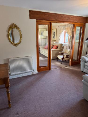 a living room with a mirror and a couch at The Stables East Lodge Country House in Great Rowsley