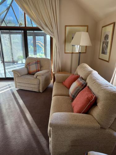 a living room with a couch and a chair at The Stables East Lodge Country House in Great Rowsley