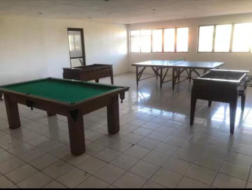 a room with two ping pong tables and two pianos at Residencial Ayambra in Natal