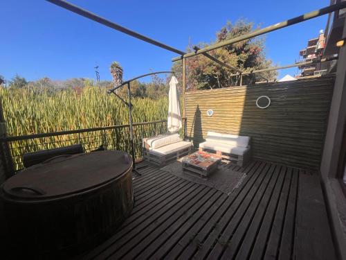 eine Holzterrasse mit einem Whirlpool und Stühlen darauf in der Unterkunft Oceana Suites Remanso de Algarrobo in San Antonio