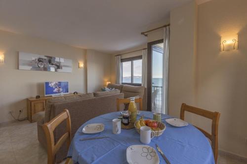 a living room with a blue table with food on it at Apartamento con increibles vistas al mar in Can Picafort