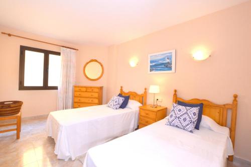 a bedroom with two beds and a window at Apartamento con increibles vistas al mar in Can Picafort