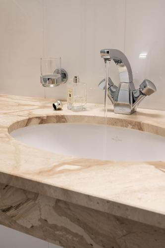 a sink with a faucet on a marble counter at Coco Boutique Hotel & Spa in Karpacz