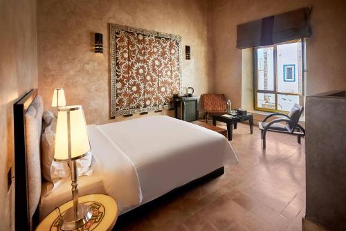 a bedroom with a large white bed and a desk at Madada Mogador in Essaouira