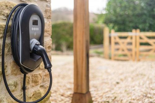 a pay phone is attached to a stone wall at Charming Coach House Retreat Near Sherborne Abbey in Pointington