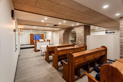 a row of wooden pews in a church with a table at Yarden Estate Hotel in Yesod Hamaala
