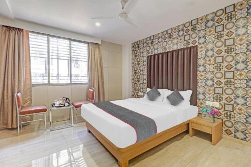a hotel room with a bed and a table and chairs at Townhouse Vandana Residency in Ambernath