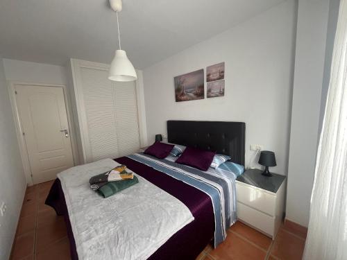 a bedroom with a large bed with purple pillows at Balcón de la Torre del Morche en Torrox Costa in El Morche