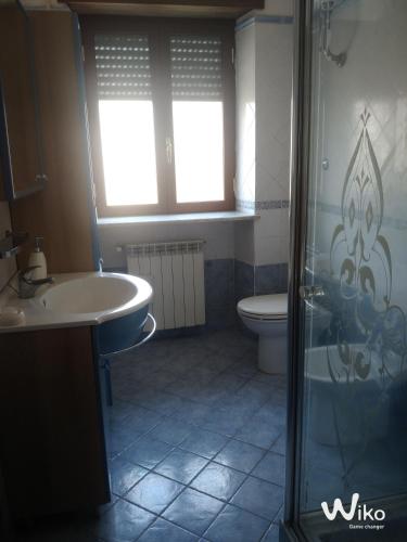 a bathroom with a shower and a sink and a toilet at Stanza in Villa in Torvaianica
