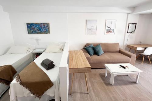 a small bedroom with a bed and a couch at Prime garden-view Studios in Arona