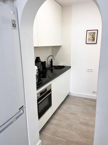 a white kitchen with a sink and a stove at Prime garden-view Studios in Arona