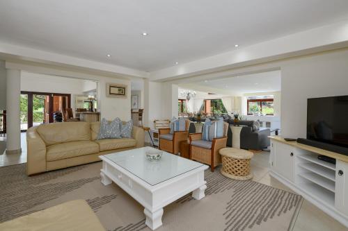 a living room with a couch and a tv at San Lameer Villa - 14014 - 5 Bedroom Luxury - 10 pax - San Lameer Rental Agency in Southbroom