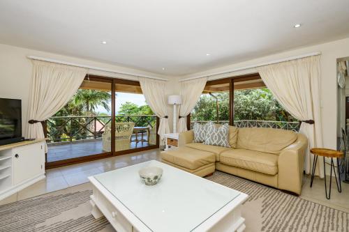 a living room with a couch and a table at San Lameer Villa - 14014 - 5 Bedroom Luxury - 10 pax - San Lameer Rental Agency in Southbroom
