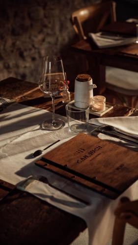 a table with a plate and a glass of wine at ECOTurisme Can Buch HOTEL in Sant Aniol de Finestras