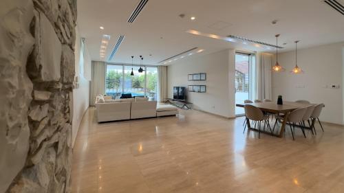 a living room and dining room with a stone wall at Vivo Mare Beachfront Villas - Seashell in Ayia Napa