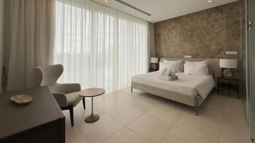 a bedroom with a bed and a desk and a chair at Vivo Mare Beachfront Villas - Seashell in Ayia Napa