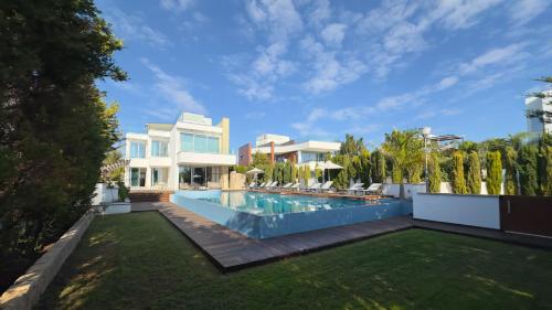 a backyard with a swimming pool and a house at Vivo Mare Beachfront Villas - Seashell in Ayia Napa