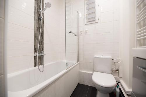 une salle de bain blanche avec toilettes et douche dans l'établissement CIA - Trocadéro, cosy & cute flat, à Paris