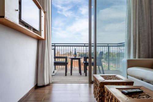 a living room with a view of a balcony at Yarden Estate Hotel in Yesod Hamaala