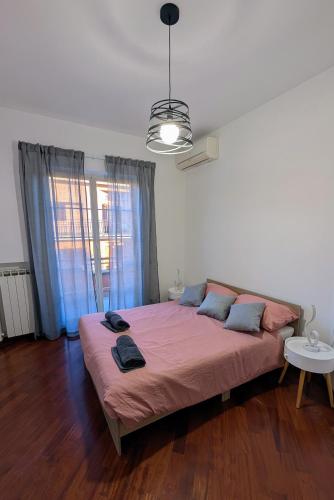 a bedroom with a bed with pink sheets and a window at Villa Fabiani in Fonte Nuova