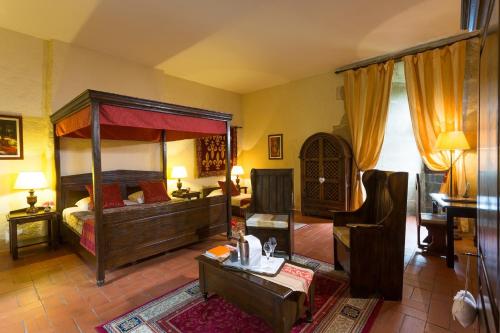 a bedroom with a canopy bed and a living room at Chateau des Ducs de Joueuse, BW Signature Collection in Couiza