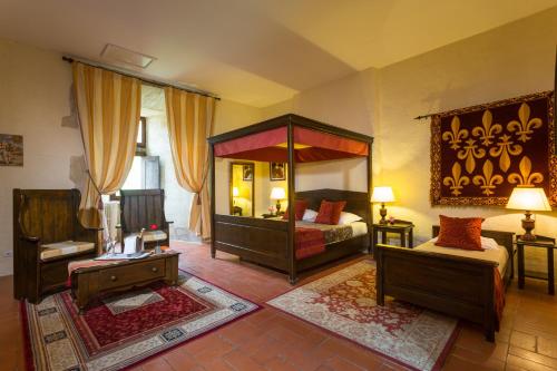 a bedroom with a canopy bed and a couch at Chateau des Ducs de Joueuse, BW Signature Collection in Couiza