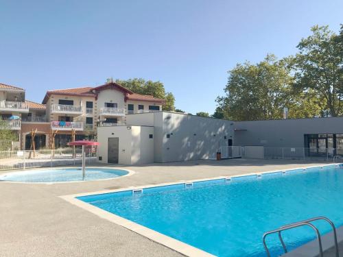 une piscine devant un immeuble dans l'établissement Couleurs Pyla T3 grande terrasse Piscine commune, à La Teste-de-Buch