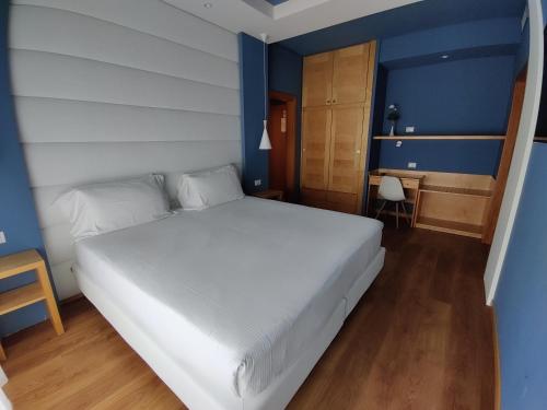 a bedroom with a large white bed and blue walls at Hotel Concord - Nel cuore di Riccione in Riccione