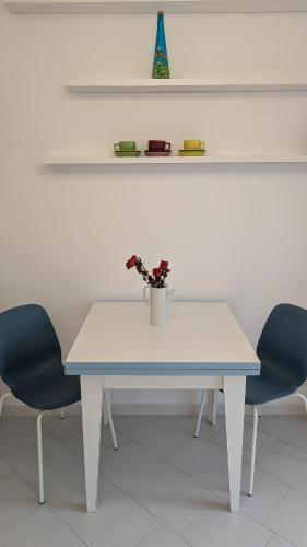 a white table with two chairs and a vase on it at Villa Fabiani in Fonte Nuova