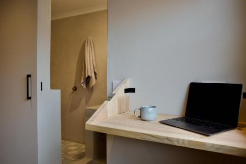 a laptop computer sitting on a counter in a bathroom at Ocean Call Inn in Plettenberg Bay