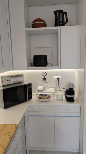 a white kitchen with a microwave and a counter top at Villa Fabiani in Fonte Nuova