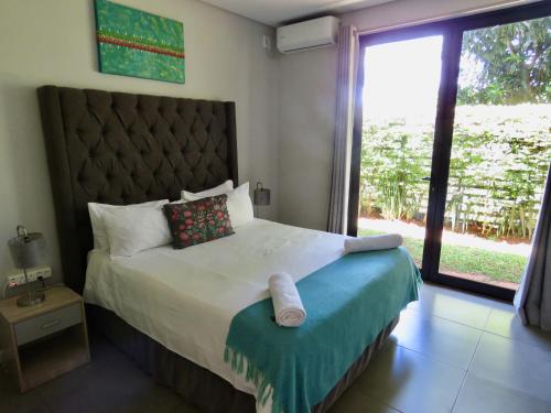 a bedroom with a large bed with a large window at The Executive - Exclusive Self-Catering Apartments - Ezulwini in Ezulwini