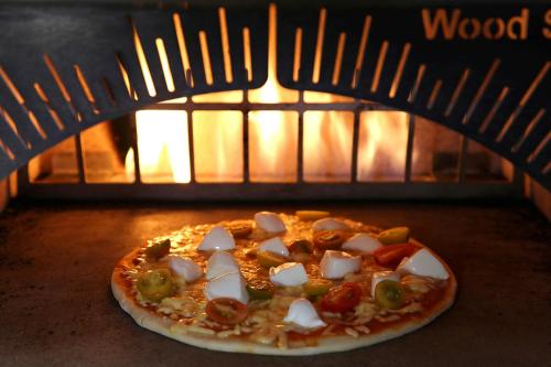 a pizza is coming out of an oven at JW Marriott Guanacaste Resort & Spa in Tamarindo