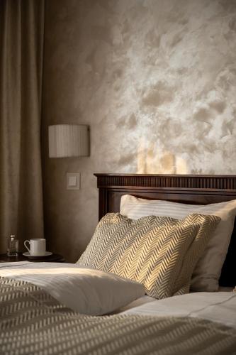 a bedroom with a bed with a headboard and a pillow at Coco Boutique Hotel & Spa in Karpacz