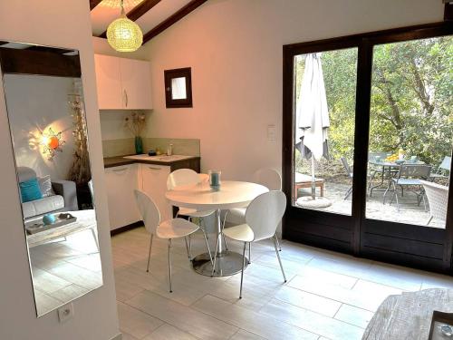 une cuisine et une salle à manger avec une table et des chaises dans l'établissement Mini-villa à 1 minute de la plage de Santa Giulia, à Porto-Vecchio