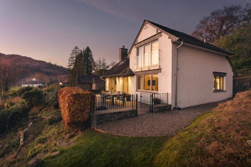 a small white house on a hill with a table at Barakat Lakes Escape, Ambleside - Ridgestone in Ambleside